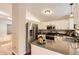 Well-lit kitchen featuring stone countertops and stainless appliances at 8432 S Upham Way, Littleton, CO 80128