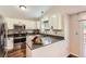 Modern kitchen with stainless steel appliances, white cabinets, and neutral countertops at 8432 S Upham Way, Littleton, CO 80128
