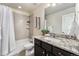 Bathroom featuring a vanity with granite countertop, a mirror, and a shower-tub combo at 1631 Aspen Meadows Cir, Denver, CO 80260