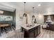 Open-concept layout with a modern kitchen island connecting to the dining and living areas at 1631 Aspen Meadows Cir, Denver, CO 80260
