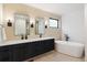 Sleek bathroom features a double vanity, modern mirrors, and a freestanding soaking tub at 2625 W 23Rd Ave, Denver, CO 80211