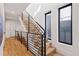 Modern staircase with sleek black railings and light wood steps, bathed in natural light from nearby windows at 2625 W 23Rd Ave, Denver, CO 80211