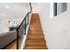 Bright staircase with hardwood steps and modern black metal railing, leading to the upper level at 2625 W 23Rd Ave, Denver, CO 80211
