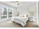 Bright bedroom with sunlit windows, neutral carpet, and a striped bedspread create a cozy and inviting atmosphere at 11487 W Grand Way, Littleton, CO 80127