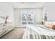 Bright bedroom with many sunlit windows, neutral carpet, striped bedspread, dresser, and a serene vibe at 11487 W Grand Way, Littleton, CO 80127