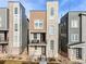 Modern three-story townhome boasts a stone facade and a charming balcony at 11487 W Grand Way, Littleton, CO 80127