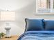 Close up of a neatly made bed with blue pillows and a side table lamp at 2695 S Logan St, Denver, CO 80210
