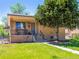 Inviting brick home with a cozy covered porch, manicured lawn, and mature tree for curb appeal at 2695 S Logan St, Denver, CO 80210