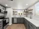 Modern kitchen with sleek gray cabinets, stainless steel appliances, and stylish floating shelves at 2695 S Logan St, Denver, CO 80210