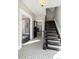 Elegant entryway with black staircase, patterned tile floors, and a view into the kitchen at 319 13Th Ave, Idaho Springs, CO 80452