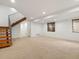 Finished basement with carpet, a staircase, and natural light from windows at 3841 Stuart St, Denver, CO 80212
