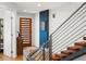 Bright, modern foyer featuring hardwood floors, statement staircase, and stylish wood door at 3841 Stuart St, Denver, CO 80212