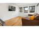 Living room with hardwood floors, a brown sofa, and multiple windows for natural light at 3841 Stuart St, Denver, CO 80212