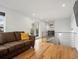 Open-concept living room featuring hardwood floors, a brown sofa, and railing to lower level at 3841 Stuart St, Denver, CO 80212