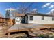 A spacious backyard deck with steps leads to a door of the home, perfect for outdoor entertaining at 1969 Uinta St, Denver, CO 80220