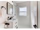 Bright bathroom featuring a white vanity, black hardware, and tiled shower with a window for natural light at 1969 Uinta St, Denver, CO 80220