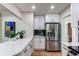 Bright kitchen with stainless steel refrigerator, quartz counters, and tile backsplash at 1969 Uinta St, Denver, CO 80220