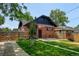 A well-maintained backyard featuring a brick home with a charming pergola-covered patio and privacy fence at 2636 N Glencoe St, Denver, CO 80207