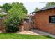 Backyard with a wooden gate, brick structure and stone pavers with a view of the main house at 2636 N Glencoe St, Denver, CO 80207