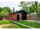 Backyard featuring brick garage with black door and manicured lawn at 2636 N Glencoe St, Denver, CO 80207