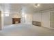 Spacious basement with carpeted floors, brick fireplace, and classic radiator at 2636 N Glencoe St, Denver, CO 80207