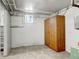 Unfinished basement featuring a storage cabinet, painted walls, and a small window at 2636 N Glencoe St, Denver, CO 80207
