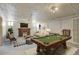 Spacious basement featuring a pool table, comfortable seating, and a brick fireplace, great for recreation at 2636 N Glencoe St, Denver, CO 80207