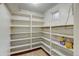 Basement storage room with extensive shelving, a window and painted white at 2636 N Glencoe St, Denver, CO 80207