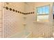 Classic tiled bathroom featuring a tub, built in shelves and decorative tile at 2636 N Glencoe St, Denver, CO 80207