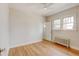 Light bedroom with hardwood floors, ceiling fan, and radiator at 2636 N Glencoe St, Denver, CO 80207