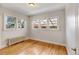 Bright bedroom featuring hardwood floors, radiator heating, and multiple windows for natural light at 2636 N Glencoe St, Denver, CO 80207