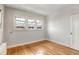 Bright bedroom featuring hardwood floors, radiator heating, and multiple windows for natural light at 2636 N Glencoe St, Denver, CO 80207