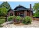 A charming brick home with a well-maintained front yard featuring mature trees and decorative stone accents at 2636 N Glencoe St, Denver, CO 80207