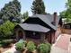 Charming brick home featuring a classic design, manicured landscaping, and a dark shingle roof at 2636 N Glencoe St, Denver, CO 80207