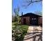 View of a detached brick garage with modern black door and trim; includes a well-maintained lawn at 2636 N Glencoe St, Denver, CO 80207
