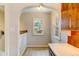 Hallway featuring white walls and trim, tile floors, an arched entryway and a bright window at 2636 N Glencoe St, Denver, CO 80207