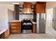 Kitchen with wood cabinets, stainless steel appliances, quartz countertops and a brick accent wall at 2636 N Glencoe St, Denver, CO 80207