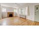 Bright living room features a brick fireplace, hardwood floors, and a view of the front yard at 2636 N Glencoe St, Denver, CO 80207