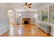 Living room with hardwood floors, a brick fireplace, radiator heat, and three large windows at 2636 N Glencoe St, Denver, CO 80207