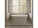 Bright and airy bathroom with a freestanding tub and window framed by built-in shelving for storage or decor at 5470 S Highline Cir, Greenwood Village, CO 80121