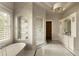 An elegant bathroom featuring a soaking tub, a glass-enclosed shower, and beautiful marble finishes at 5470 S Highline Cir, Greenwood Village, CO 80121