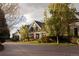 Charming home featuring a circular driveway, manicured lawn, and welcoming front porch with stately columns at 5470 S Highline Cir, Greenwood Village, CO 80121
