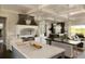 Bright kitchen featuring marble countertops, island with sink, stainless steel appliances, and decorative lighting fixtures at 5470 S Highline Cir, Greenwood Village, CO 80121