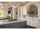 Elegant kitchen with marble countertops, gray island, patterned backsplash, and pendant lighting fixtures at 5470 S Highline Cir, Greenwood Village, CO 80121
