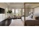 Light-filled main bedroom with a four-poster bed, large windows offering outdoor views, and a comfortable seating area at 5470 S Highline Cir, Greenwood Village, CO 80121
