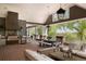 Expansive outdoor kitchen featuring a built-in grill, stone counters, a covered dining area, and ample seating at 5470 S Highline Cir, Greenwood Village, CO 80121