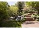 Backyard water feature with a rock waterfall cascading beside brick steps and manicured plants at 5470 S Highline Cir, Greenwood Village, CO 80121