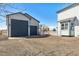 Exterior view of a two-car garage and house with gravel driveway and white fence at 16651 Tree Haven St, Hudson, CO 80642