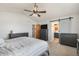 Bedroom featuring vaulted ceiling, barn door to the bath, neutral tones, and ample closet space at 16651 Tree Haven St, Hudson, CO 80642