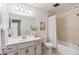 Bright bathroom featuring white fixtures, ample cabinet space, shower and neutral tiling at 5425 Camargo Rd, Littleton, CO 80123